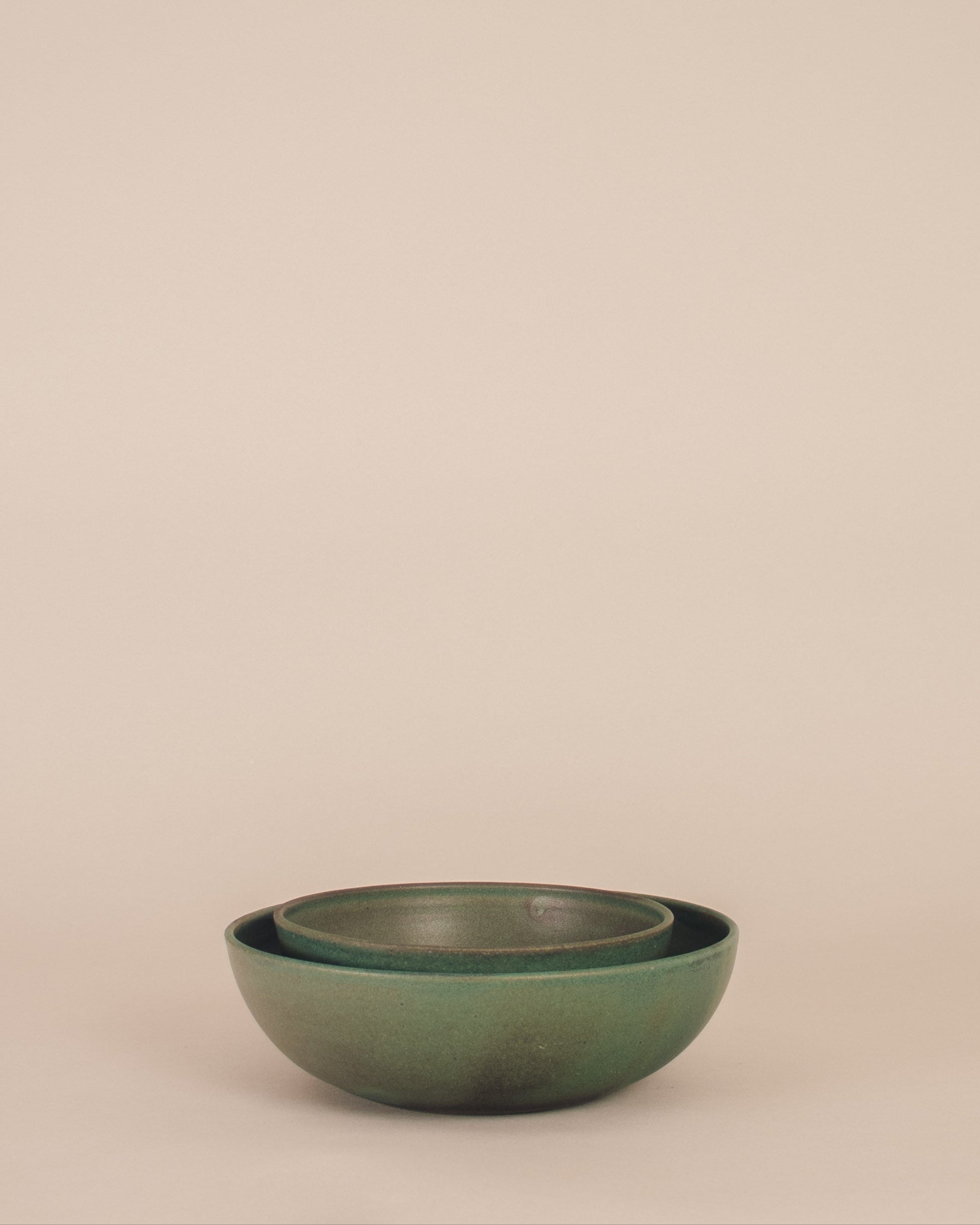 Green ceramic bowls on a beige background