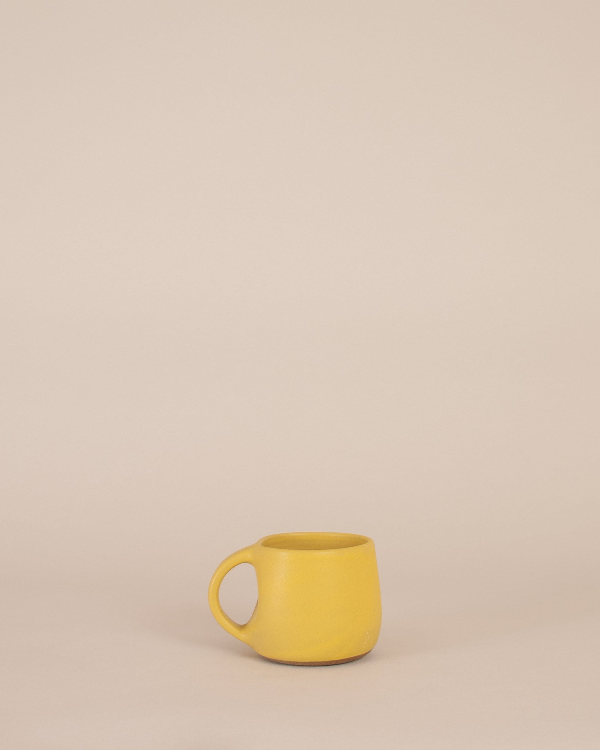 Yellow mug on a beige background